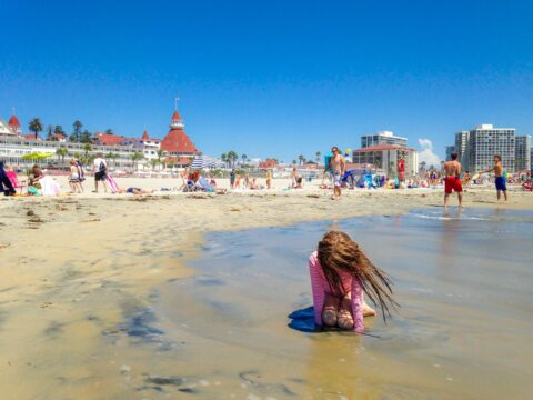 My daughter plays on the beach in front of Hotel del Coronado.