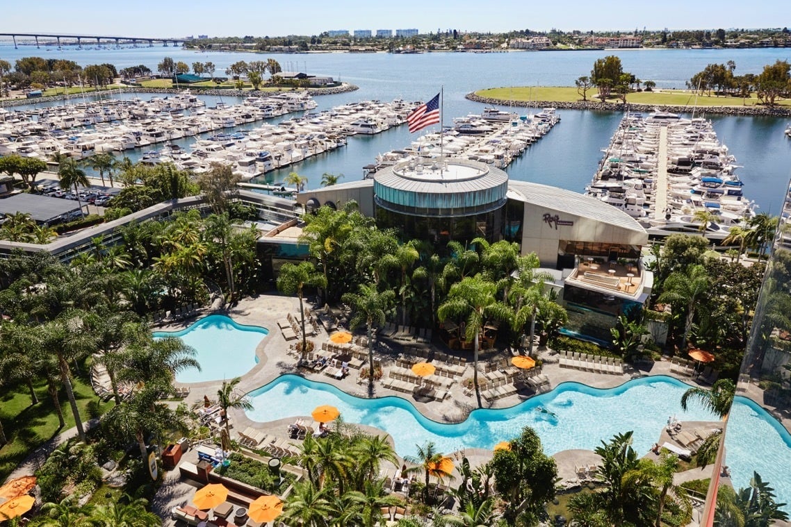 Aerial view of the Marriott Marquis San Diego hotel pool with docked boats in the background.