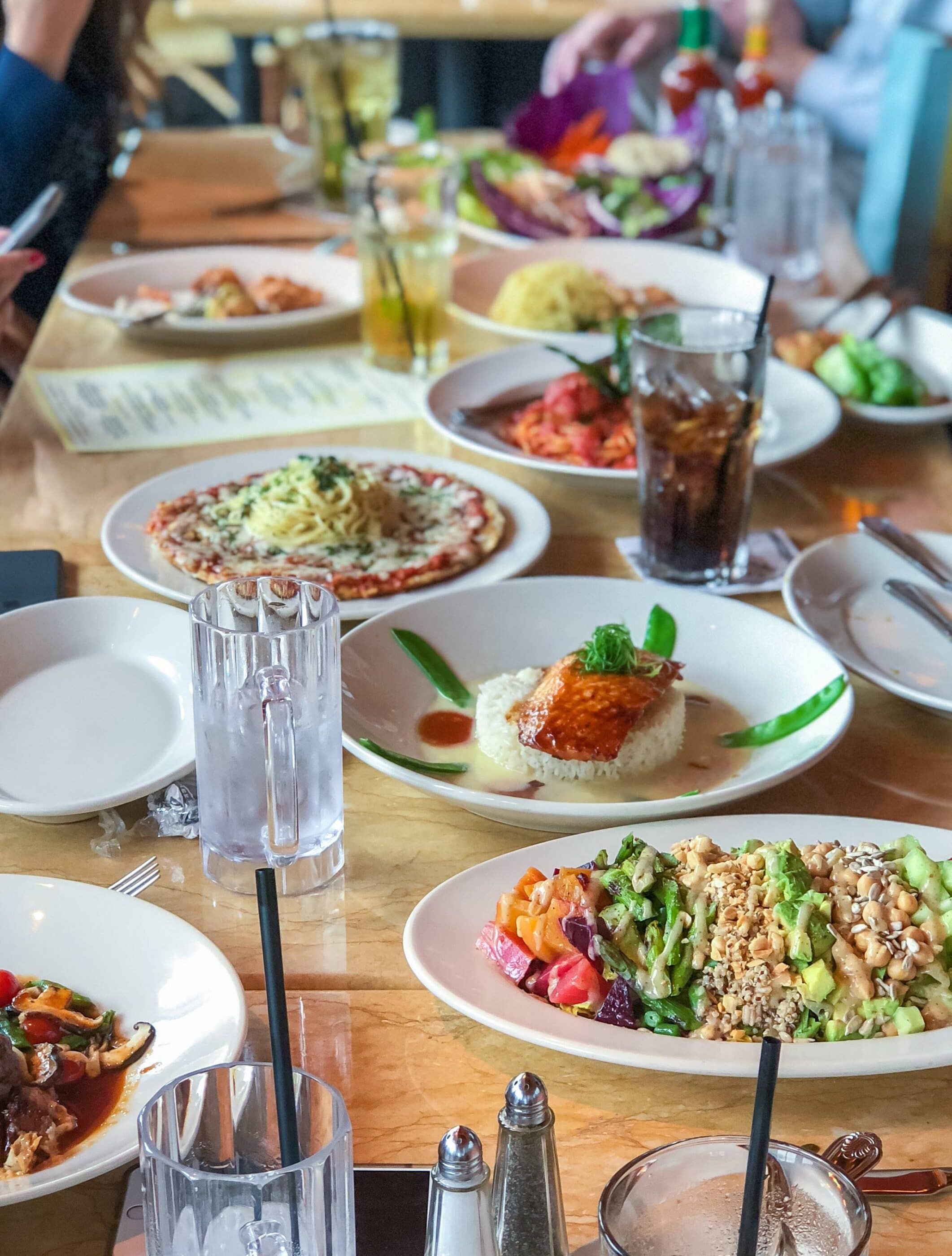 A table full of entrees and appetizers at The Cheesecake Factory.