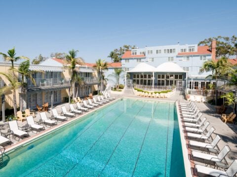 The Lafayette Hotel swimming pool surrounded by lounge chairs on a sunny day.