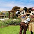 Mickey Mouse and Minnie Mouse stand in front of Disney Explorers Lodge in Hong Kong.