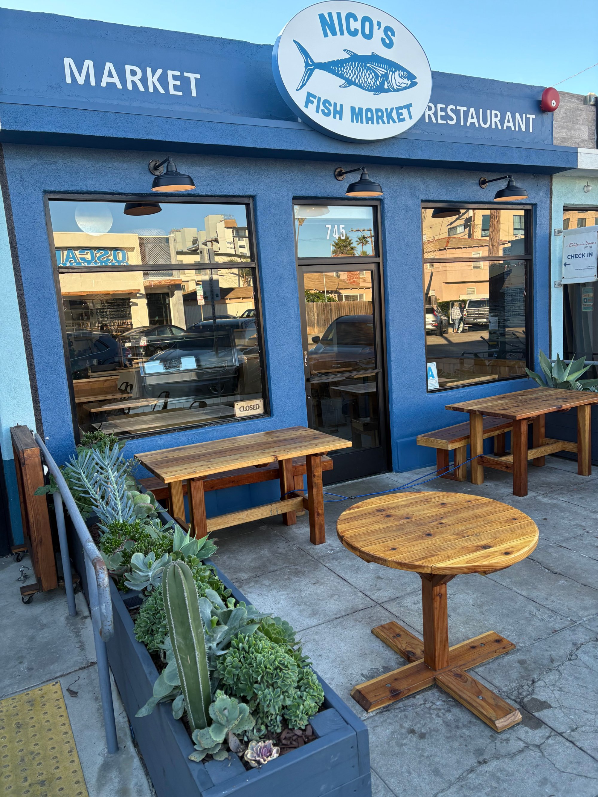 Nico's Fish Market exterior photo with wooden seating in front.