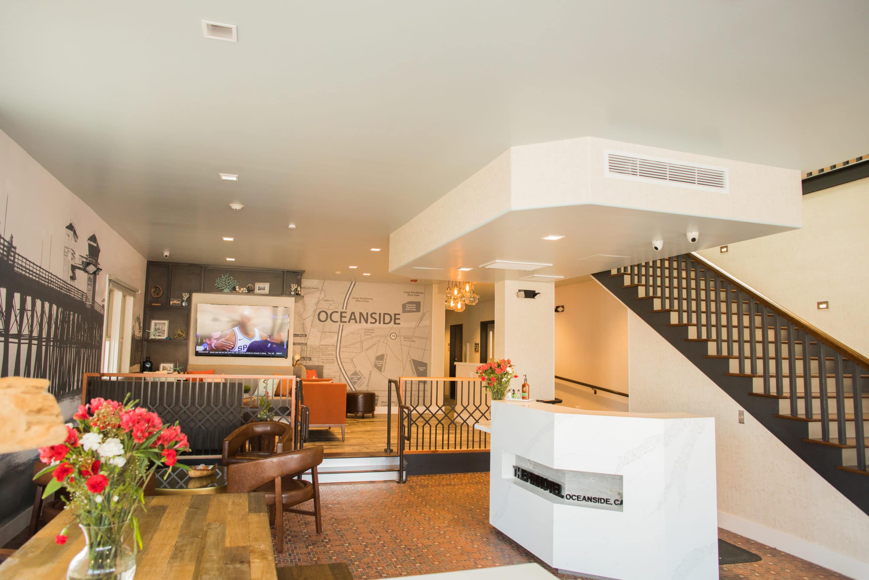 Hotel lobby with clean white lines, hardwood floors and orange accents