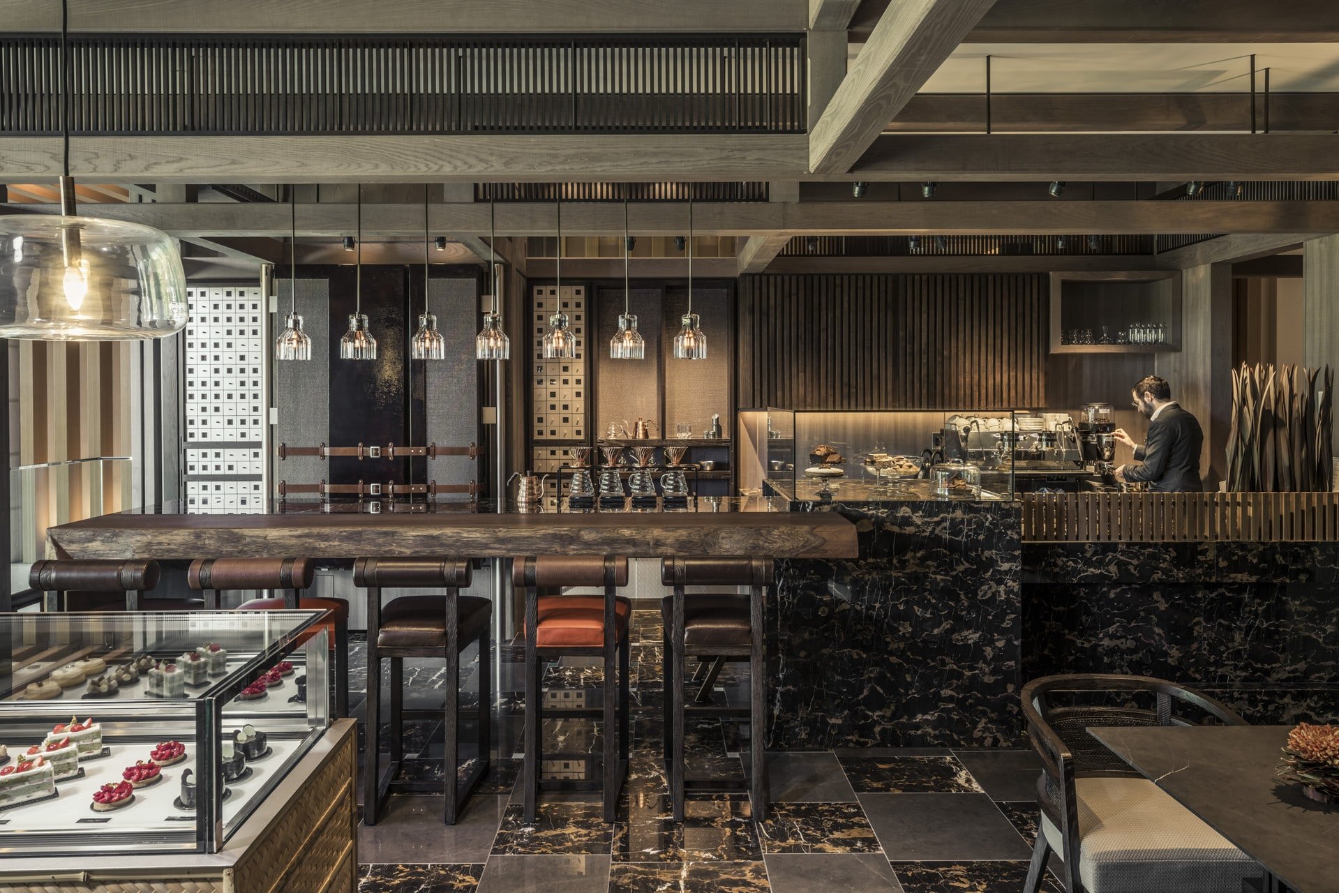The dark, zen wood bar at The Lounge offers coffee and drinks but you can take desserts out of the adjacent glass case to-go.