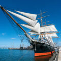 Star of India ship docked on the Embarcadero against a blue sky.