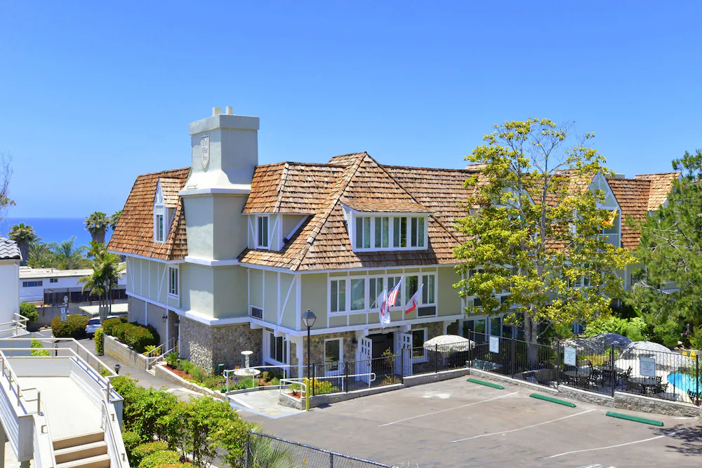 The parking lot entrance to Best Western Del Mar with the ocean in the background.
