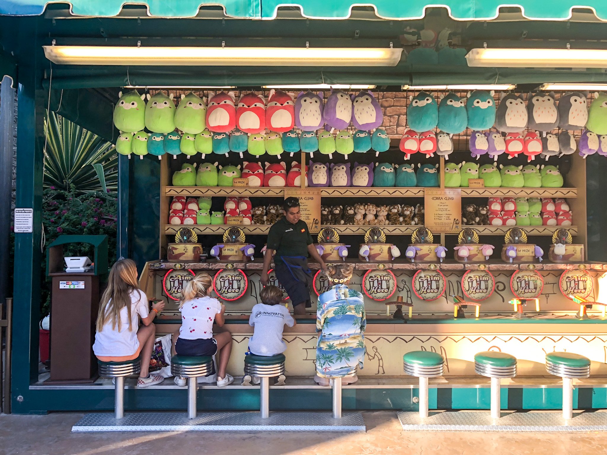 My daughter and her friends play carnival games at the theme park.