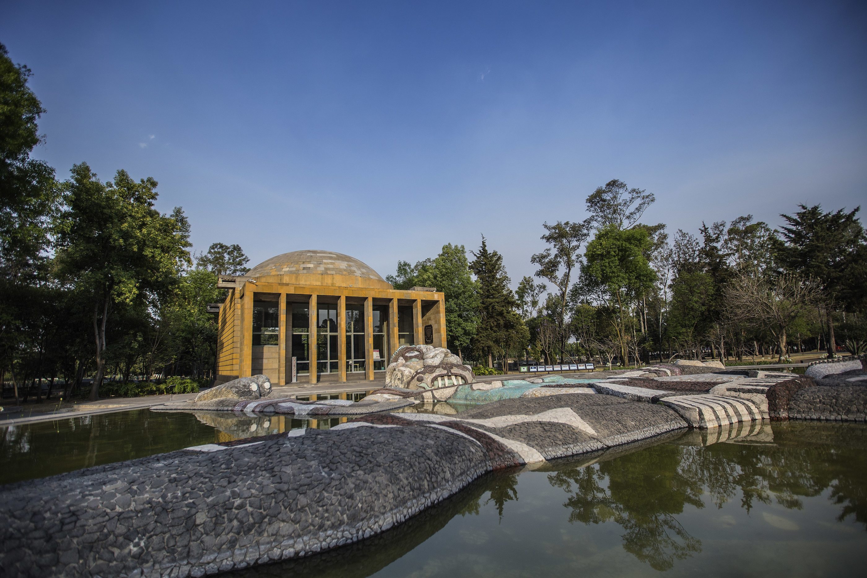 The spring with pump building in the background inside Chapultepec Forest.