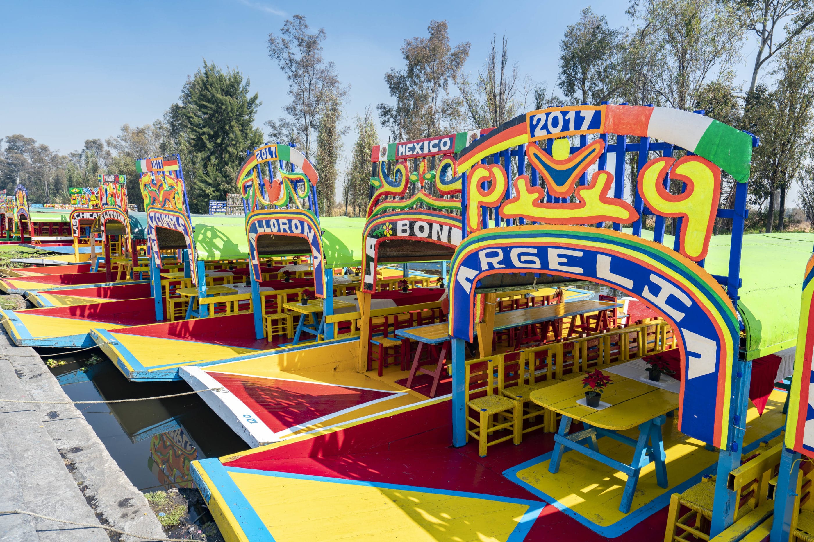 Colorful trajinera boats lined up next to each other on the water at Xochimilco.