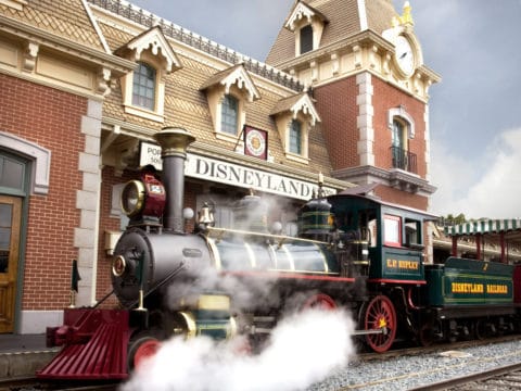 Disneyland Railroad train with the Main Street U.S.A. station in the background.