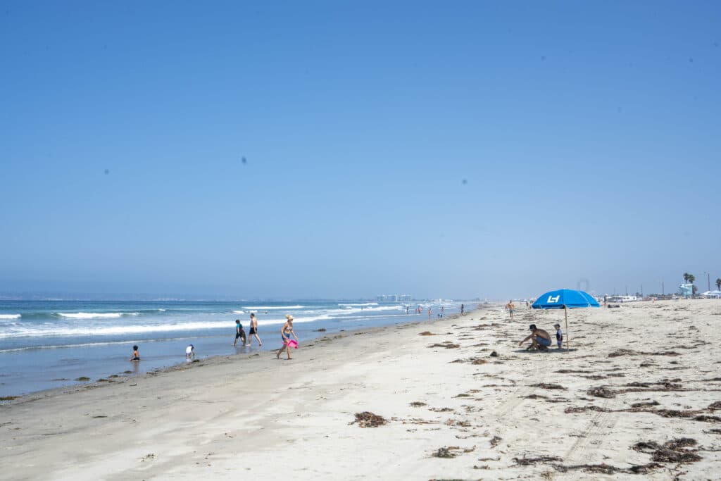 A Loews Coronado Bay Resort umbrella in the sand on Silver Strand State Beach.