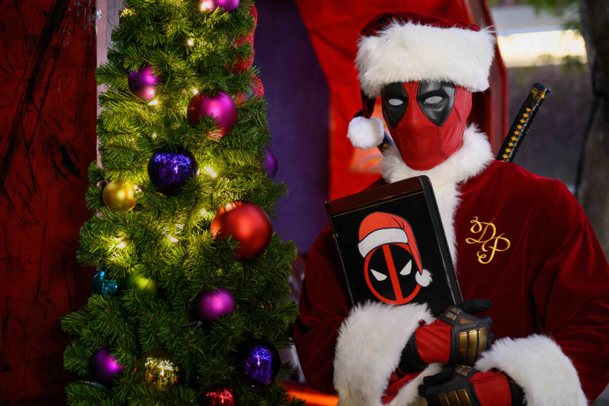 deadpool as santapool beside a Christmas tree