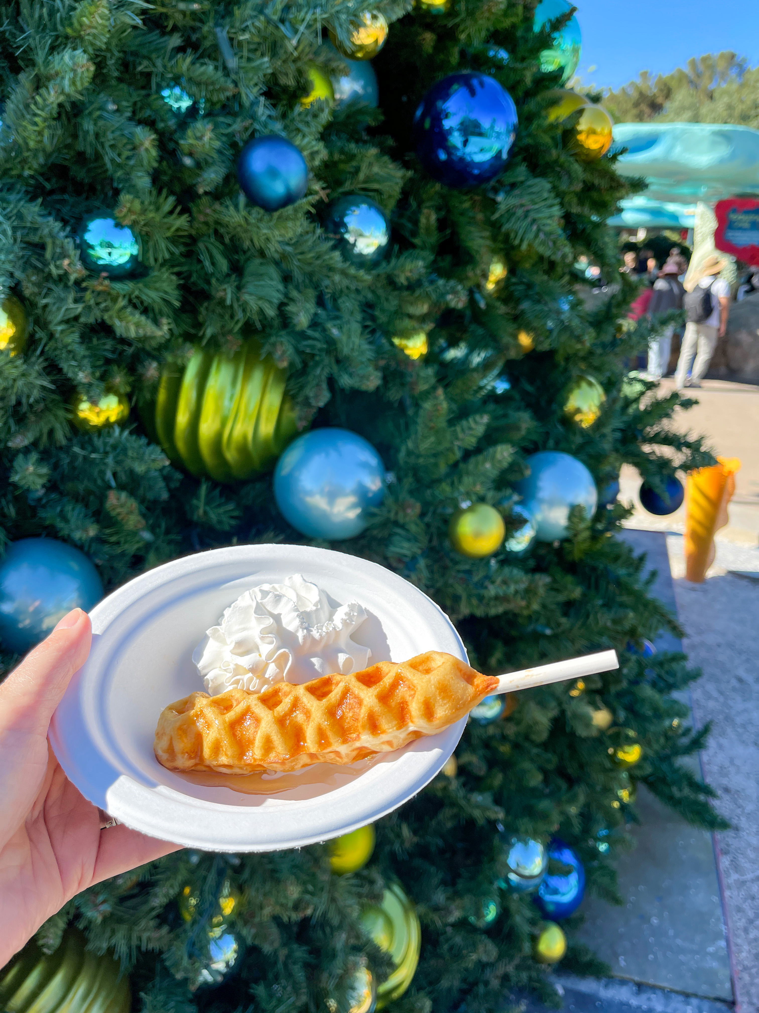My waffle on a stick in front of a Christmas tree.