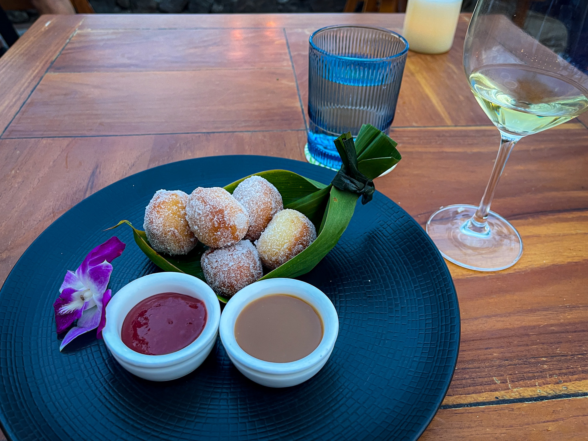 Malasadas on a plate with caramel sauce and guava gel.