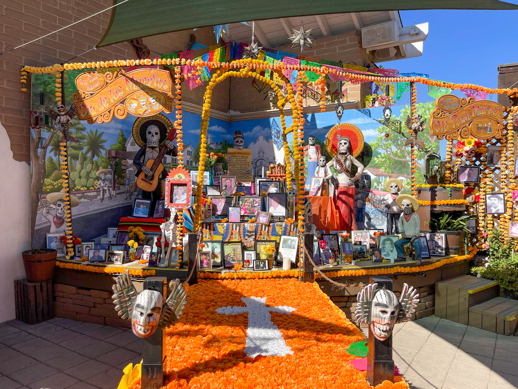 An alter full of photos, marigolds, and other decor in Old Town San Diego.