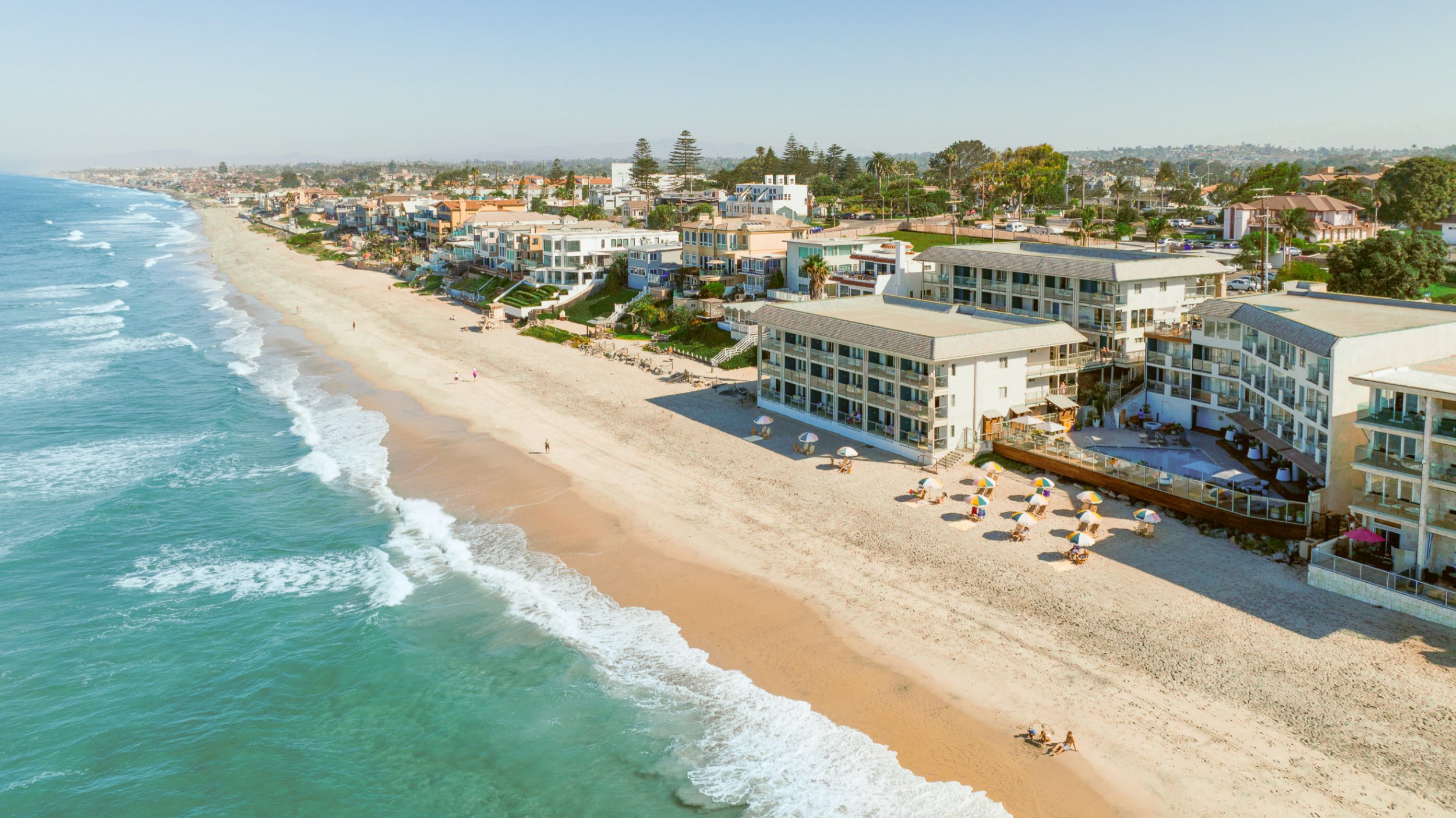 An aerial view showing the hotel right on the sand.