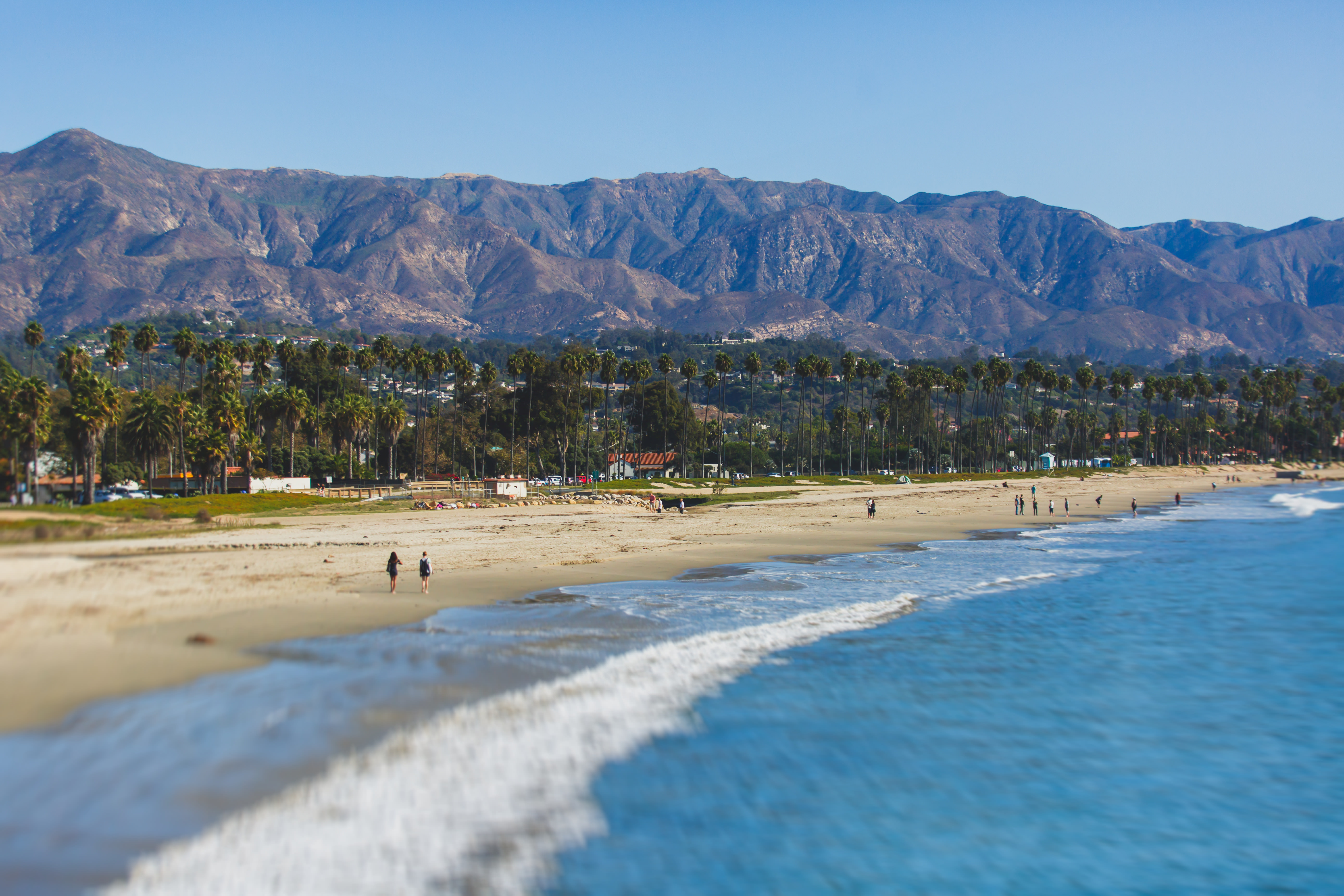 East Beach with the Santa Barbara mountains and palm tree lined board walk in the background.