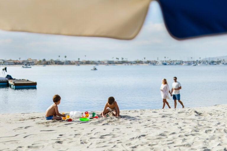 Kids playing sand at the beach in front of Bahia Resort Hotel.
