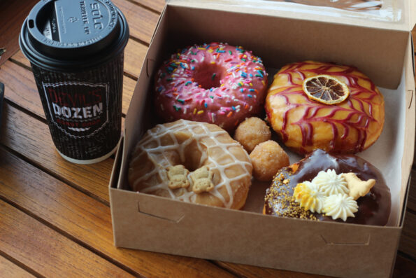 Four colorful donuts and a coffee.