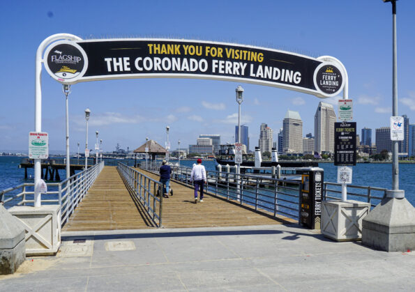 A family walks on the pier toward the Coronado Ferry.