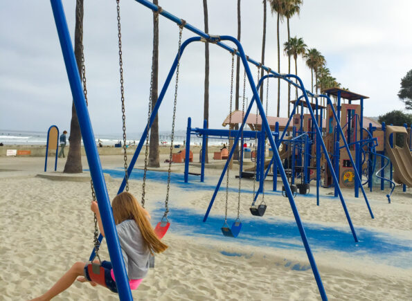 Katie's daughter swings on a play structure at Kellogg Park.