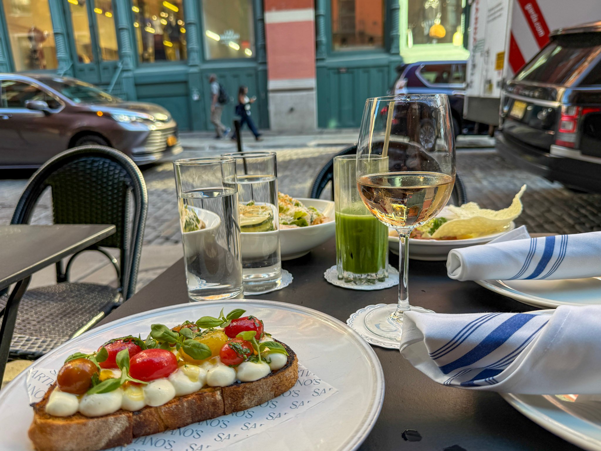 Ricotta toast and rose wine on a table at the outdoor cafe seating.