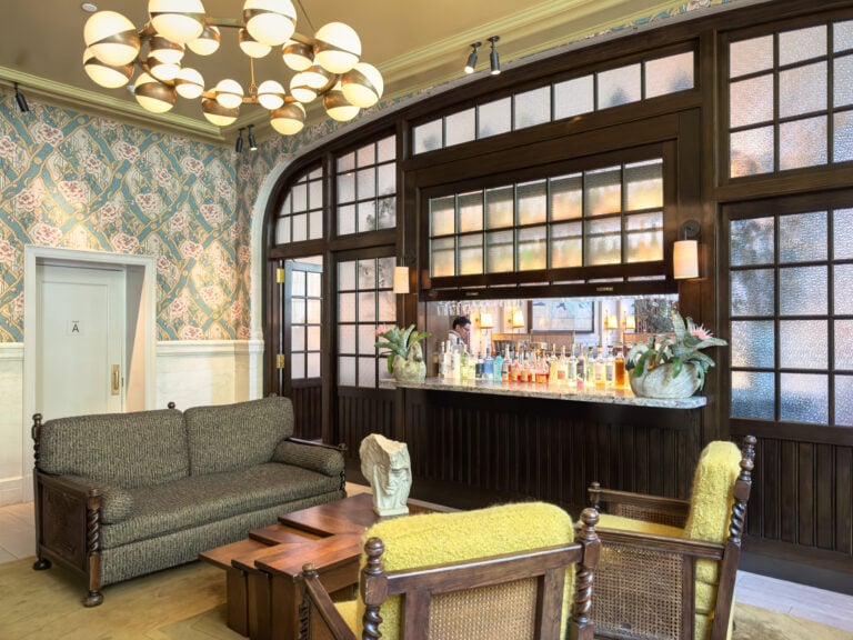 The lobby at Nine Orchard on the Lower East Side, with floral wallpaper and a bar