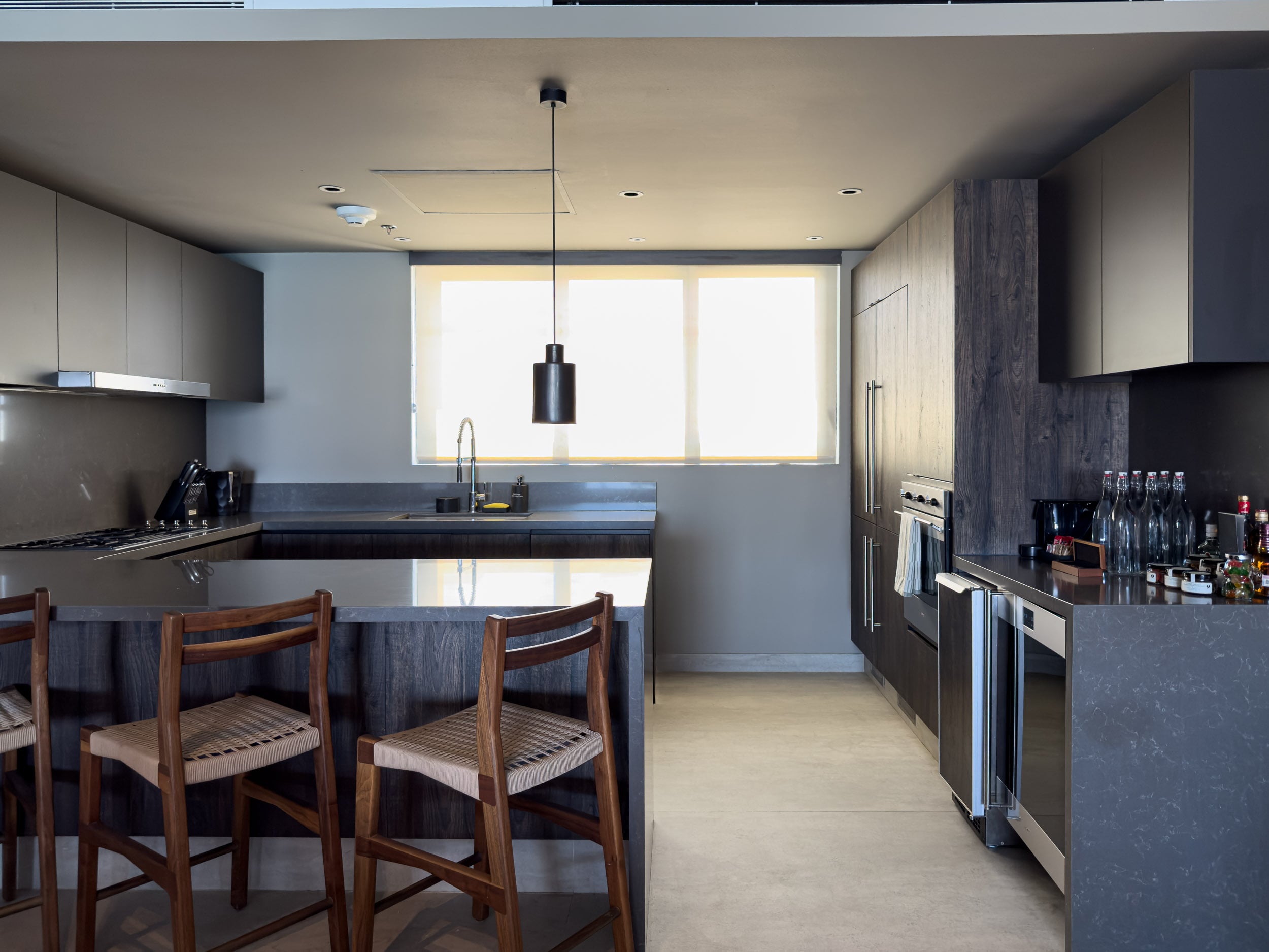The fully equipped kitchen in a residence at The Cape, with an island and bar seating