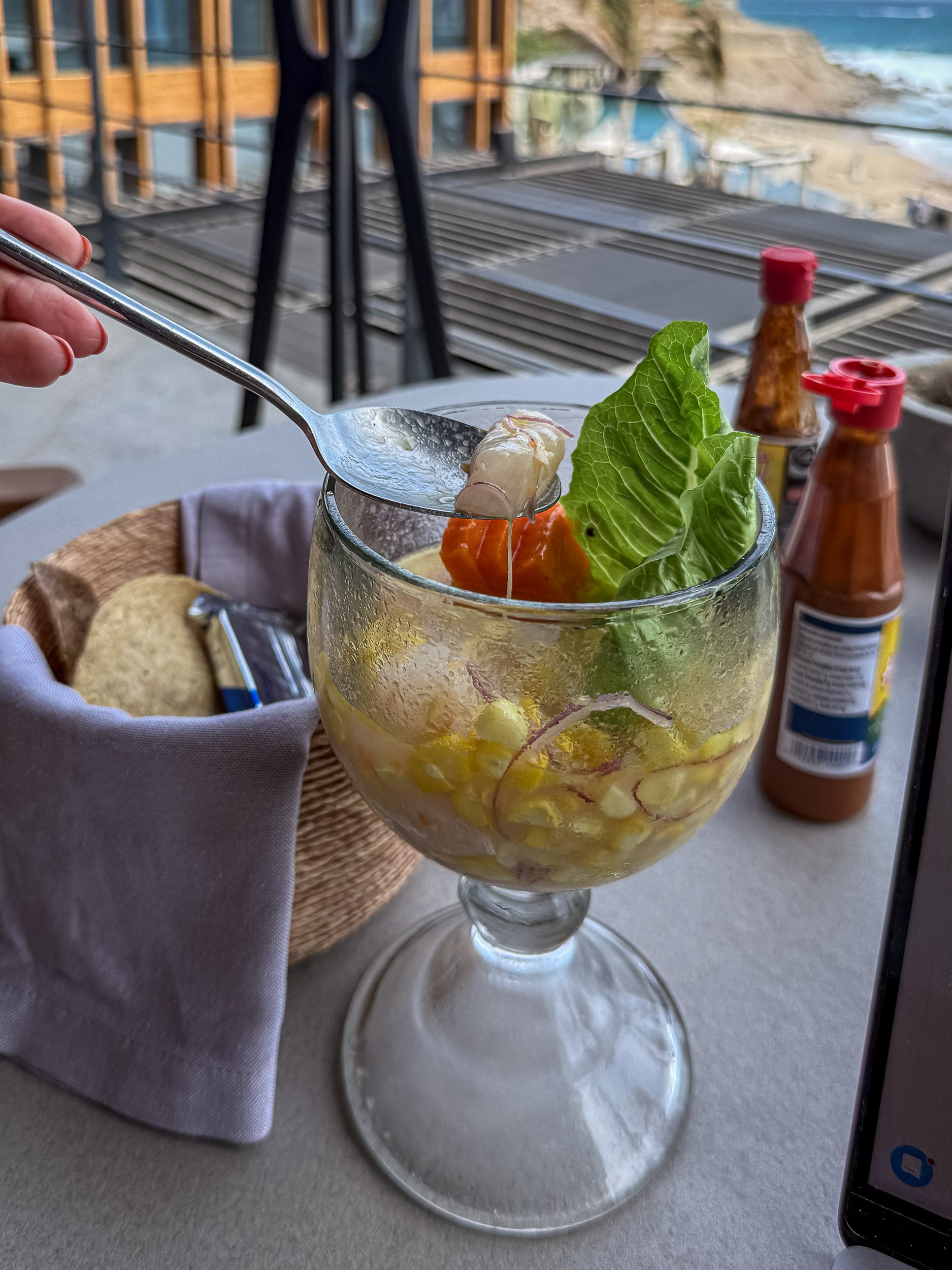 Seafood ceviche served in a glass with tortilla chips and hot sauces at The Cape, a Thompson Hotel