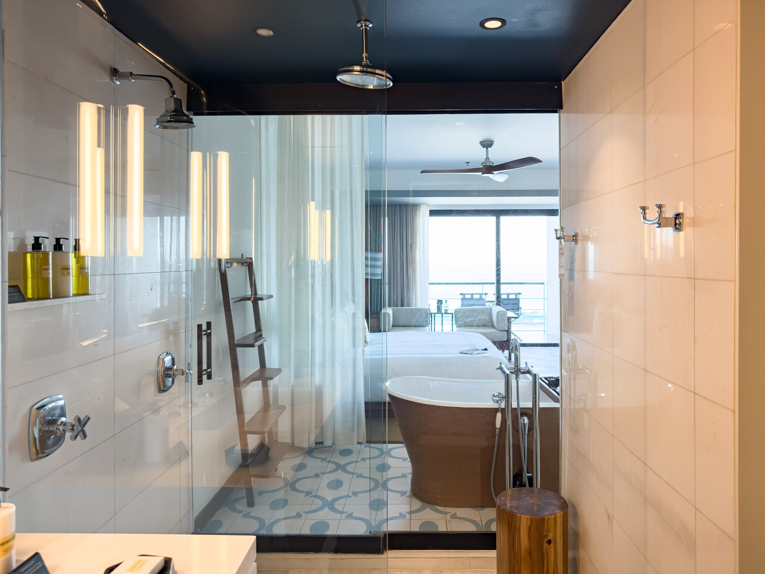 Walk-in shower and freestanding soaking tub in a guest bathroom at The Cape, a Thompson Hotel