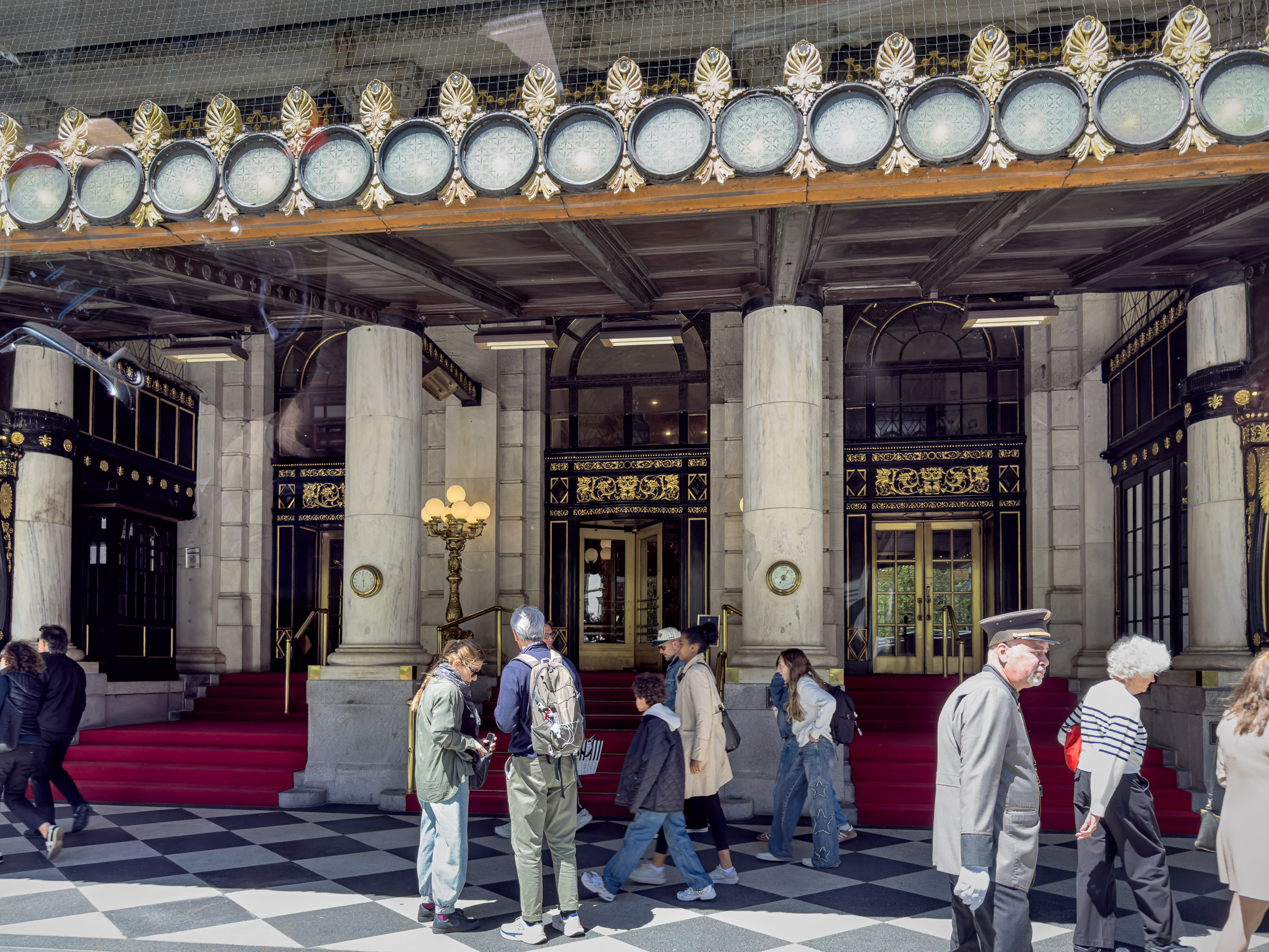 Entrance portico with checkerboard floor and doormen in uniform at The Plaza Hotel New York