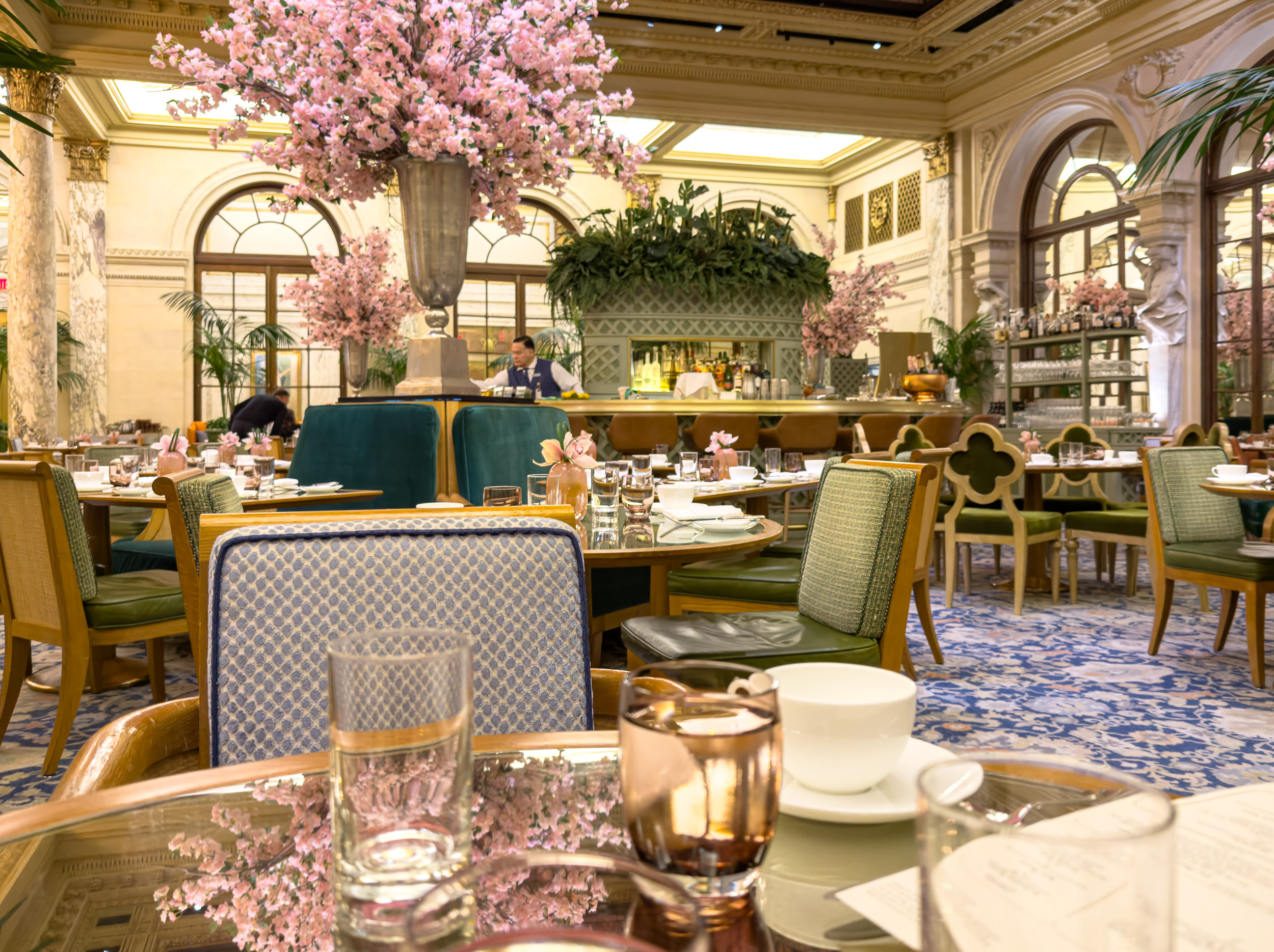 The Palm Court set for tea beneath cherry blossom arrangements at The Plaza Hotel New York