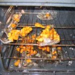 A shattered Pyrex glass baking dish in an oven