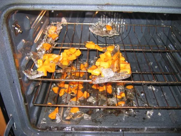 A shattered Pyrex glass baking dish in an oven