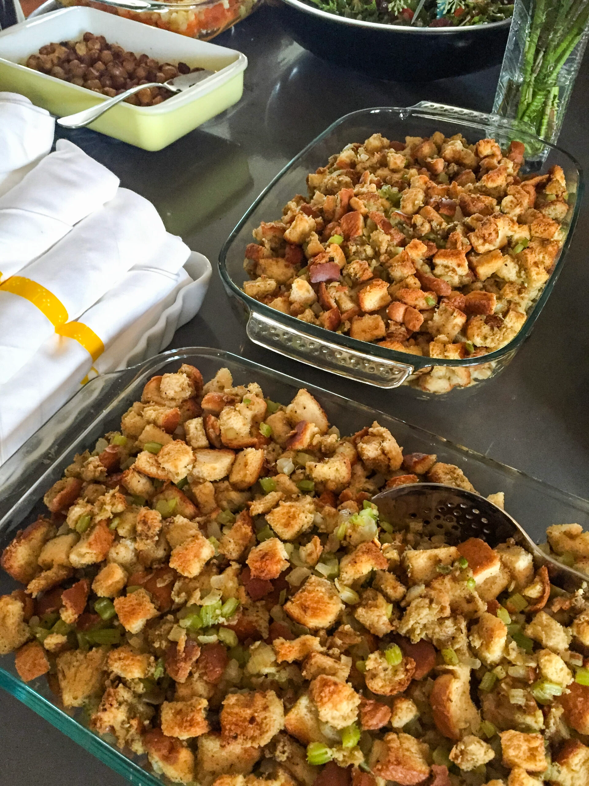 Two pans of bread and celery stuffing on a Thanksgiving table