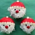 Finished Santa Claus Cupcakes on a green background.