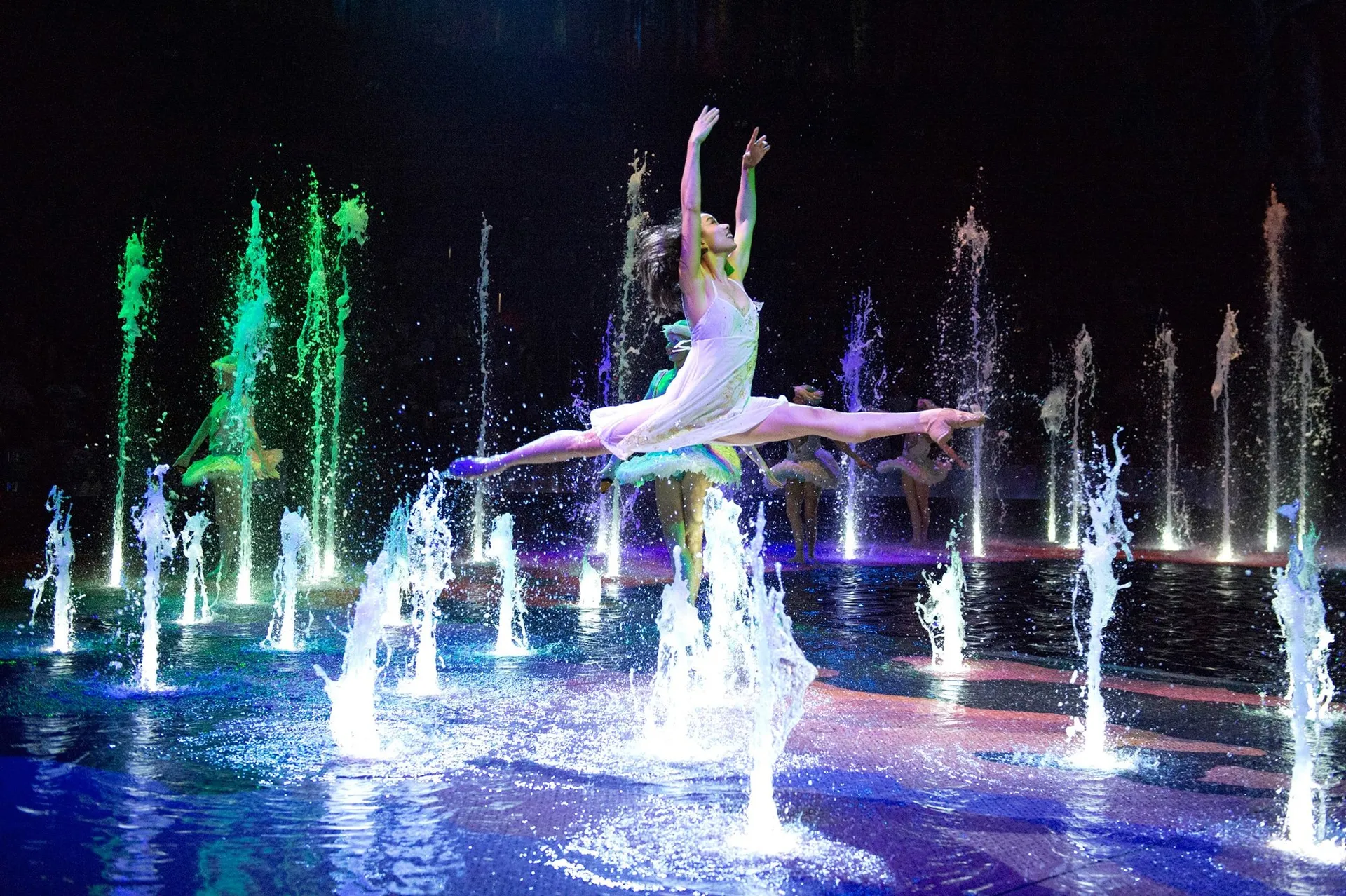 A dancer gracefully leaps over water on stage at House of Dancing Water in Macau.