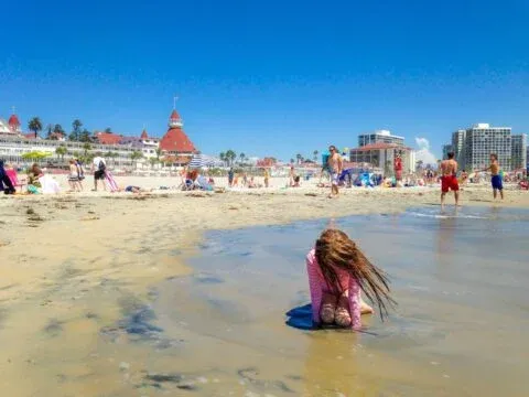 My daughter plays on the beach in front of Hotel del Coronado.