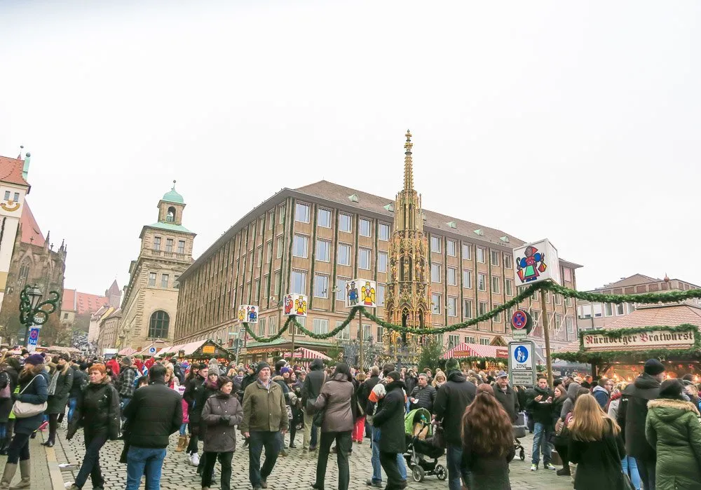 Sch&agrave;&para;ner Brunnen (beautiful fountain--the structure with the pointed top) in the middle of the Nuremberg Christmas Market