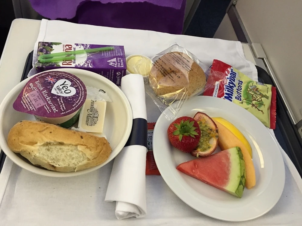 A first course kids' meal of fruit, bread rolls, juice box.