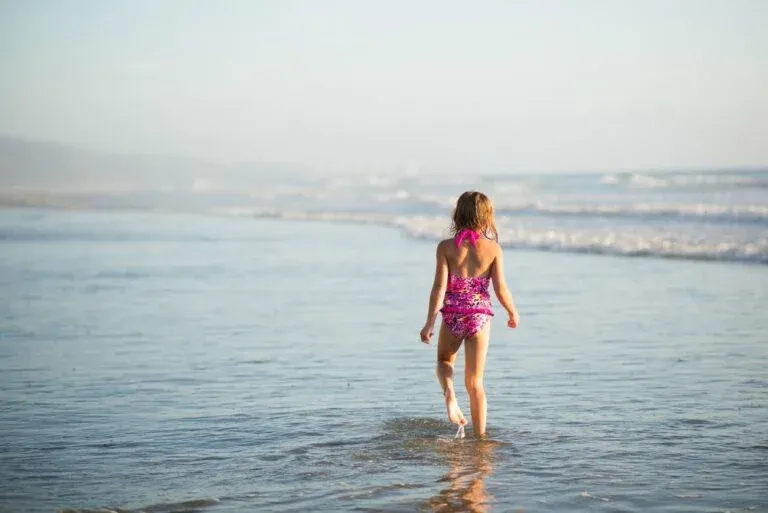 A little girl walks into the ocean on a San Diego Beach