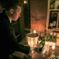 A sommelier pours wine for hotel guests in the famous Le Cinq wine cellarl