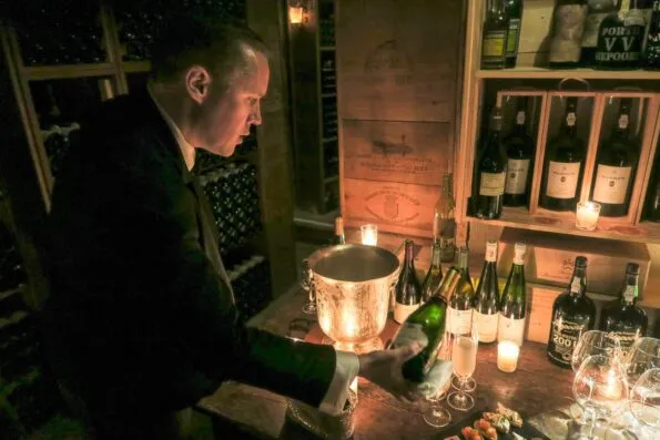 A sommelier pours wine for hotel guests in the famous Le Cinq wine cellarl
