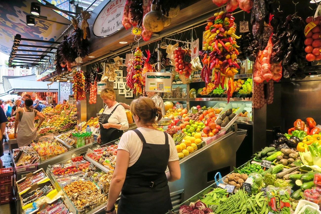 Vendors selling fruit at La Boqueria Market in Barcelona
