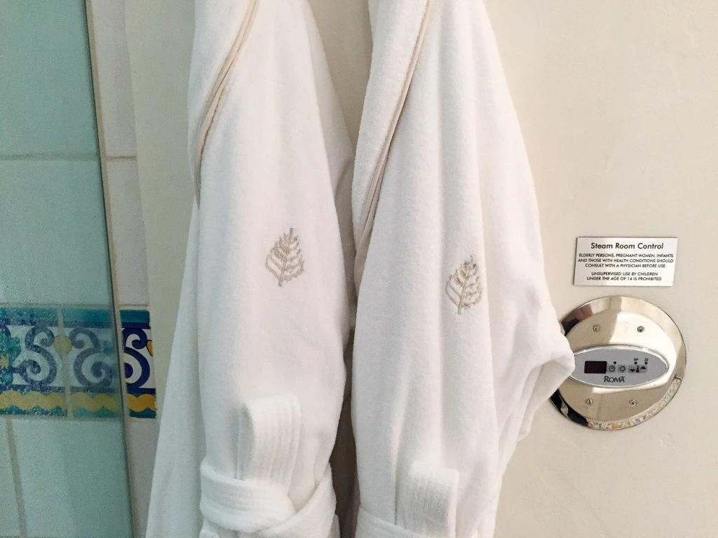 Bathrobes hanging next to steam shower controls at Four Seasons Resort The Biltmore, Santa Barbara