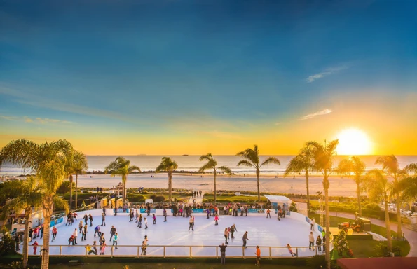 People enjoying beachside Hotel del Coronado ice skating during the holiday season.