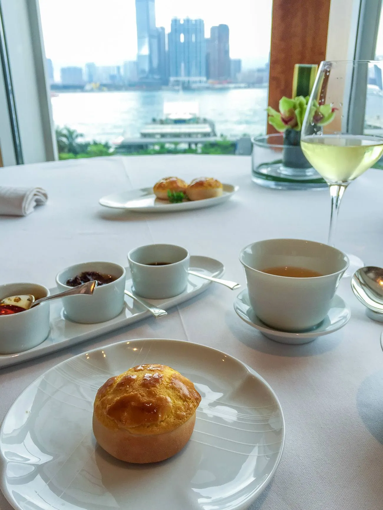 Baked barbecue pork bun and glass of Krug champagne with a view out to the harbour from a table at Lung King Heen.