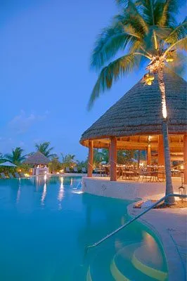 The Palapa Grill and pool at Grand Isle Resort in the Bahamas lit up at night.