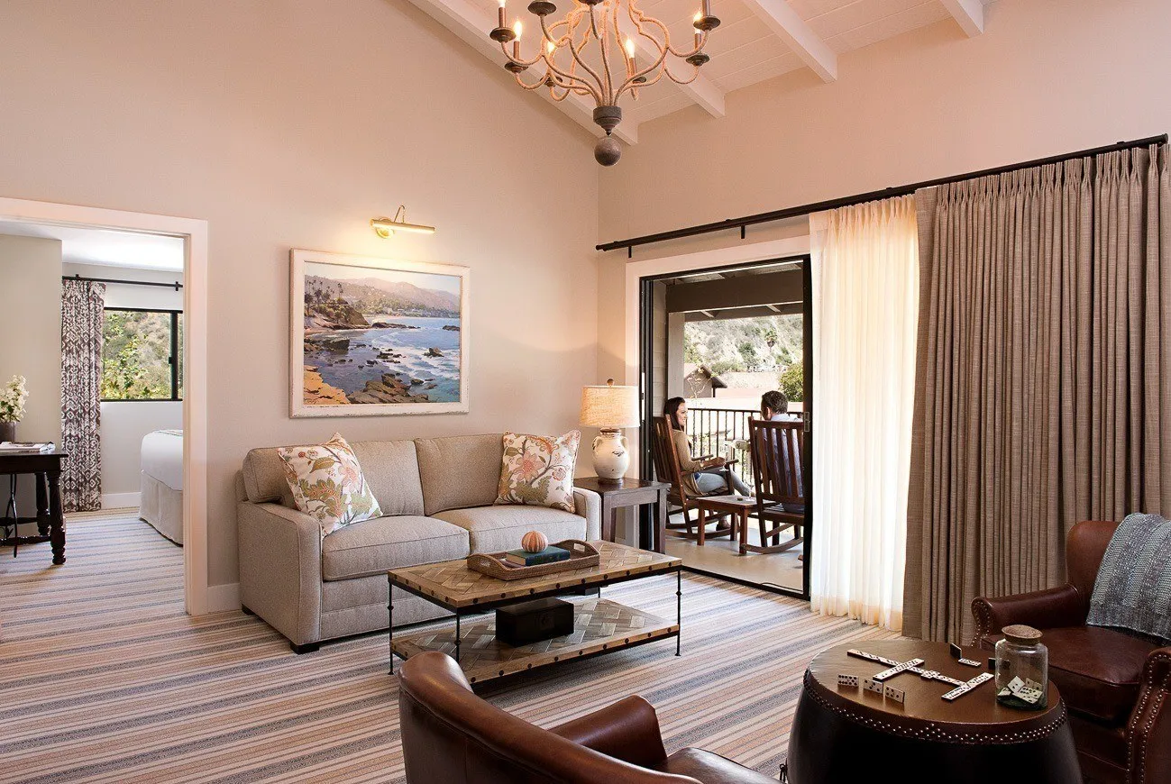 A Creeksite One Bedroom Suite living room with people sitting on the outdoor patio.