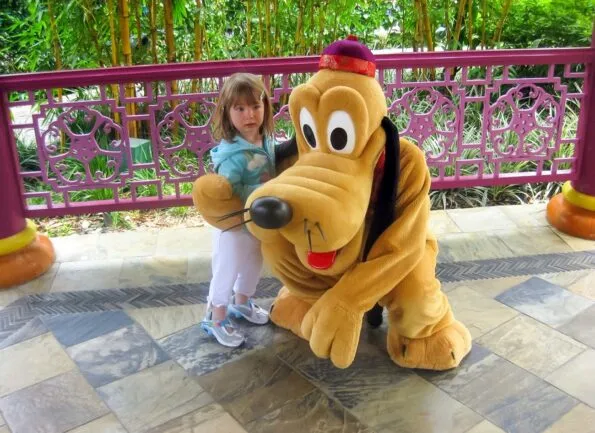 My daughter at age 2 greeting Pluto at Hong Kong Disneyland's Fantasy Garden.